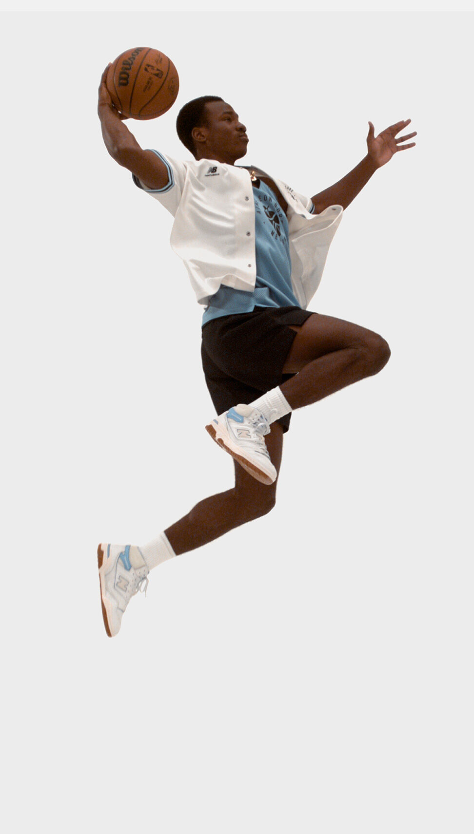 A man dunking a basketball in New Balance 650 X Aimé Leon Dore shoes and apparel