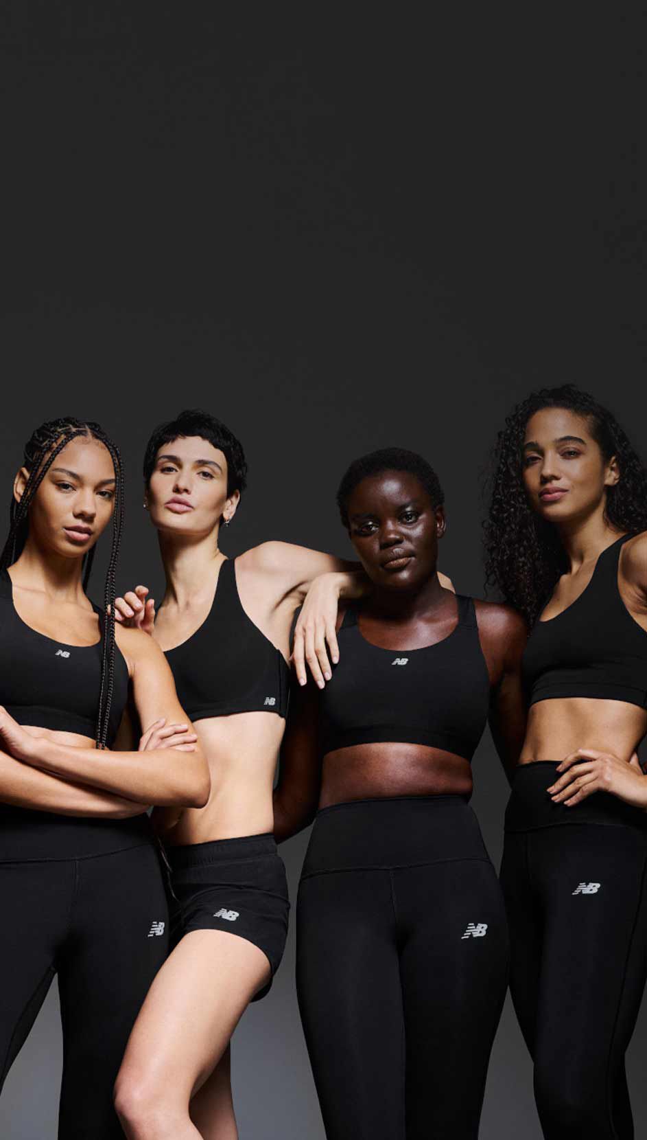 A group of women wearing sports bras and leggings in front of a black background. 