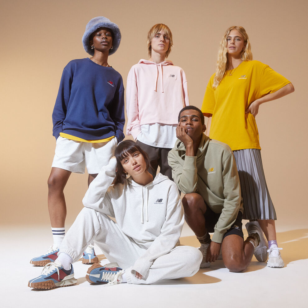 3 woman and 2 men grouped together wearing New Balance Uni-ssentials clothing and 327 shoes