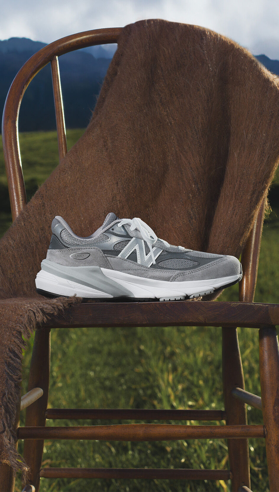 new balance 990v6 sitting on a chair