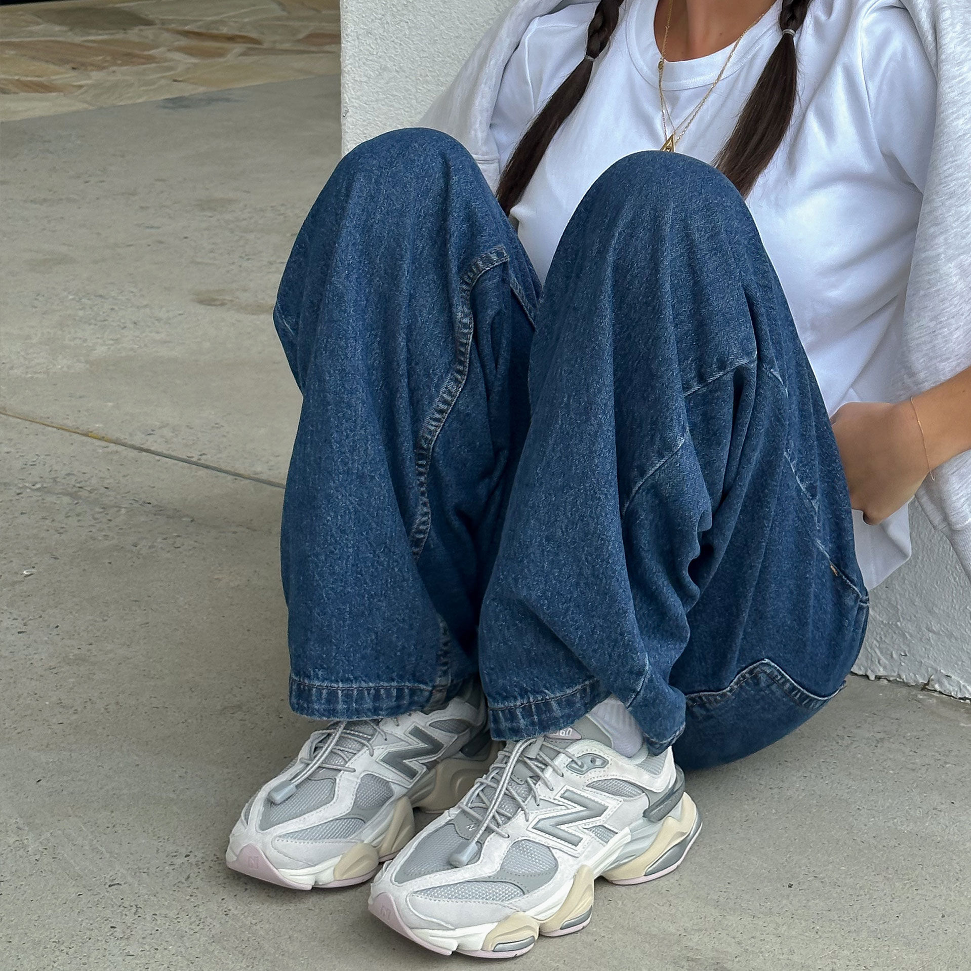 Girl in jeans and white t-shirt wearing the New Balance 9060 with toggle laces.