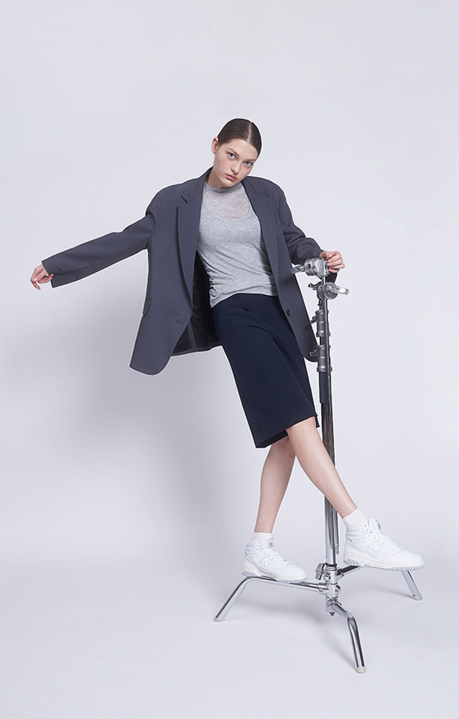 woman standing on a tripod wearing New Balance 650s
