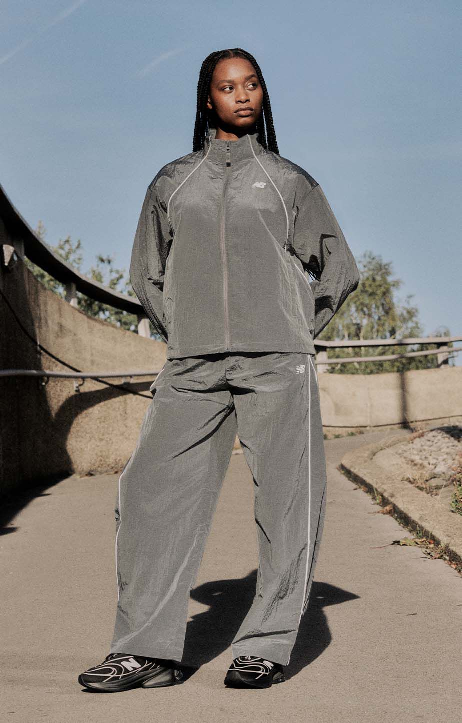 Head to toe shot of a woman wearing a NB tracksuit and Abzorb 5030 shoes. 