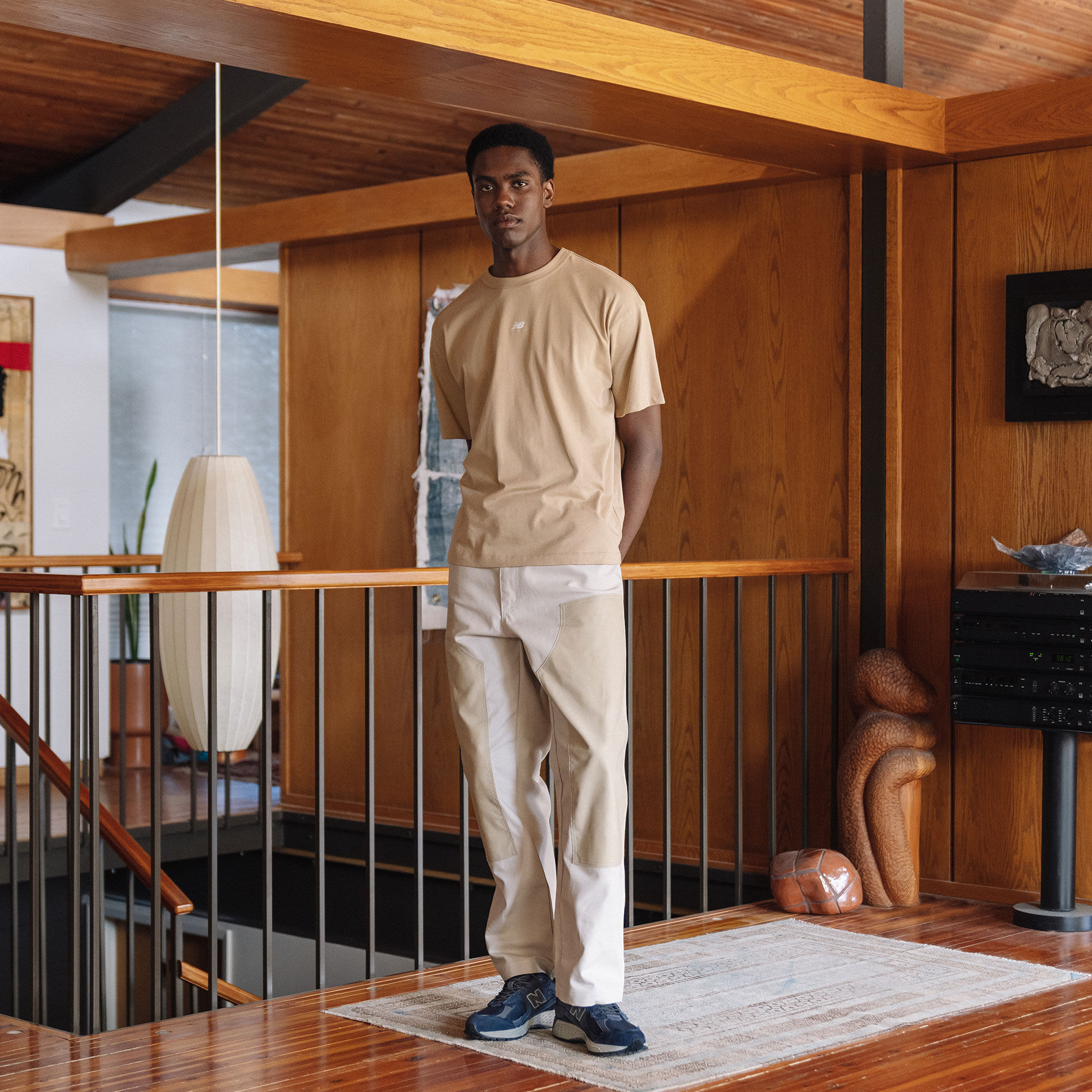 Man wearing neutral tshirt and chinos with New Balance 2002R.