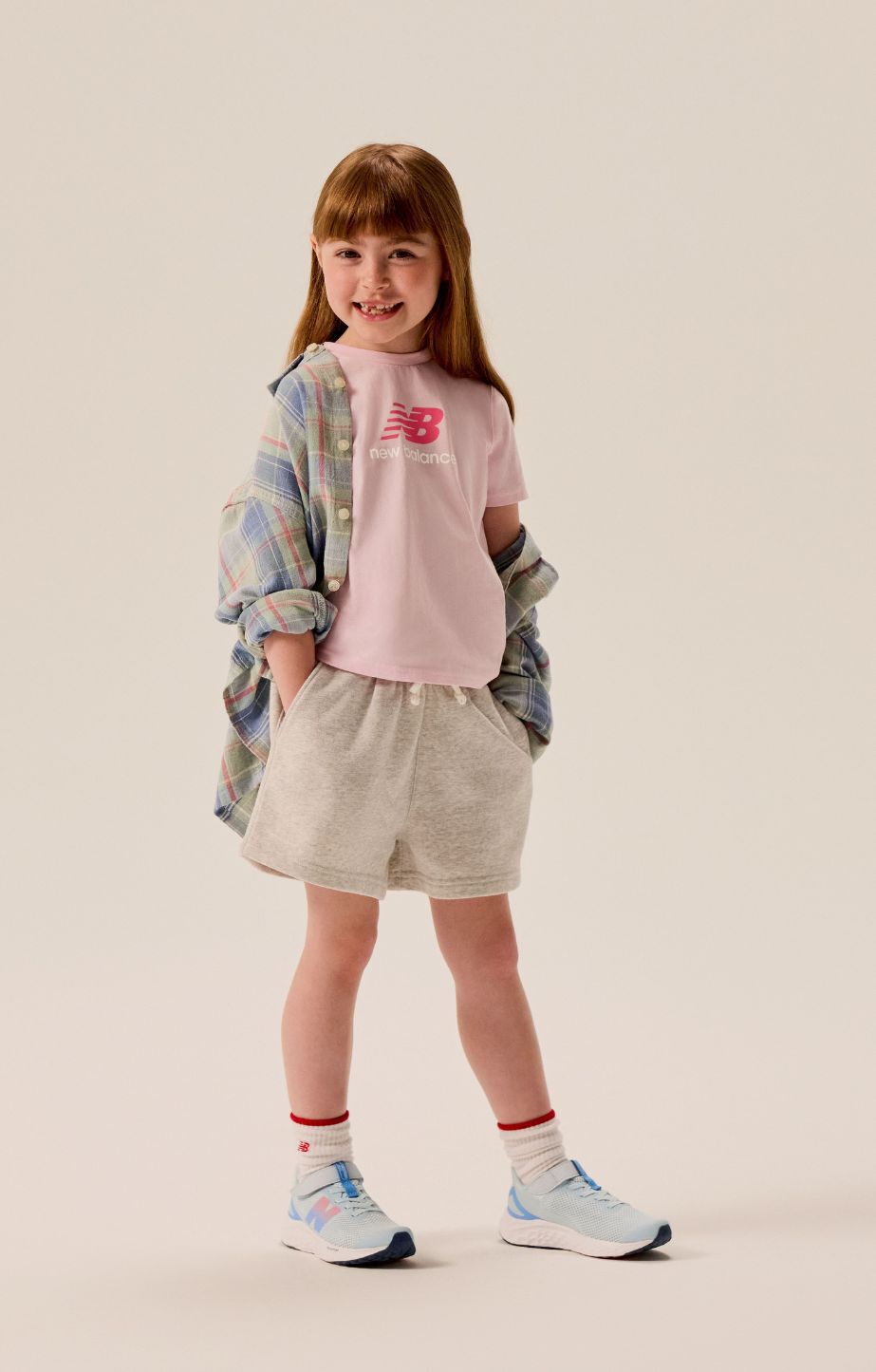 Girl standing in a studio wearing new balance fresh foam arishi v4