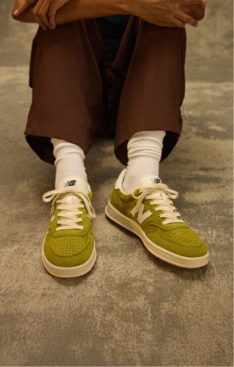 Knee down shot of a person sitting on a grungy studio backdrop 
