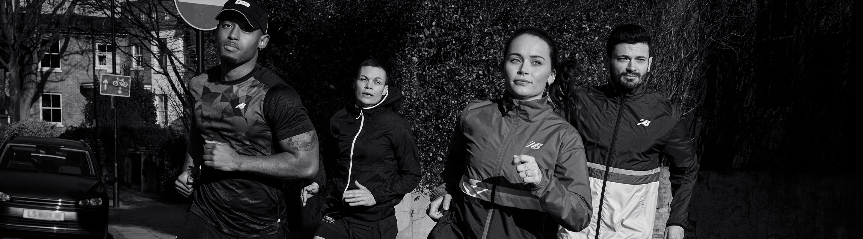 4 people running in the streets wearing New Balance athletic clothing