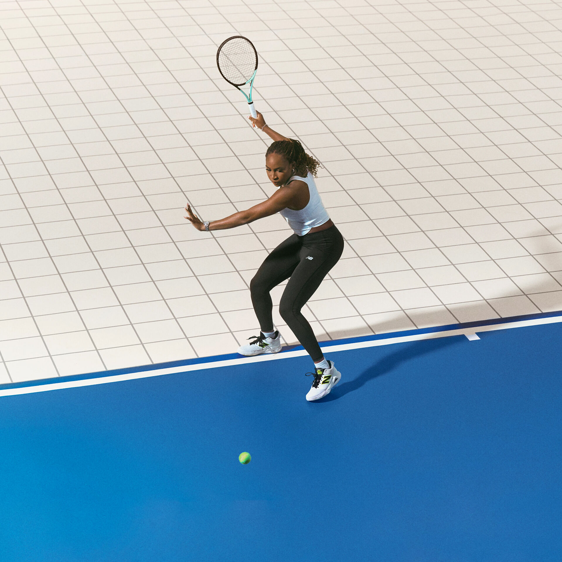 Coco Gauff playing tennis on court, wearing her New Balance tennis shoes.