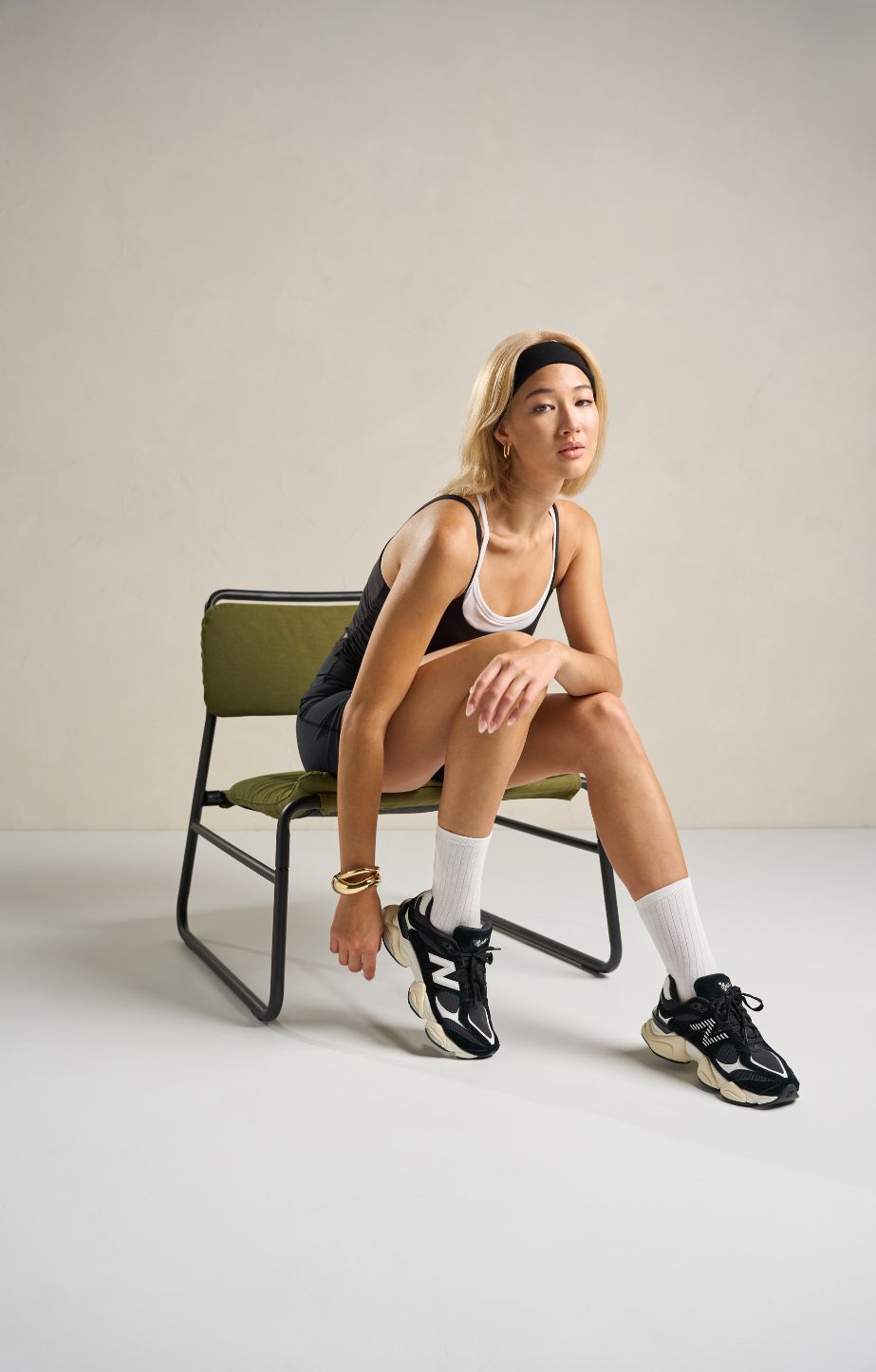 Woman sitting on a chair and wearing new balance 9060 sneakers