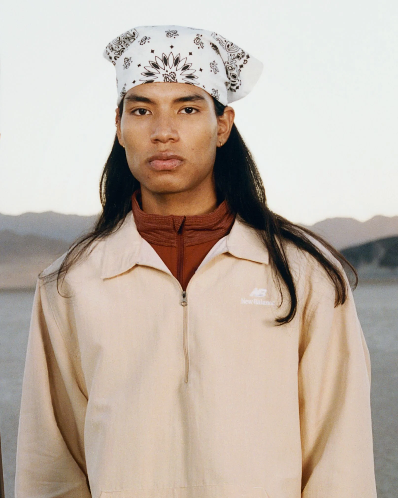 A man standing in a desert environment. 