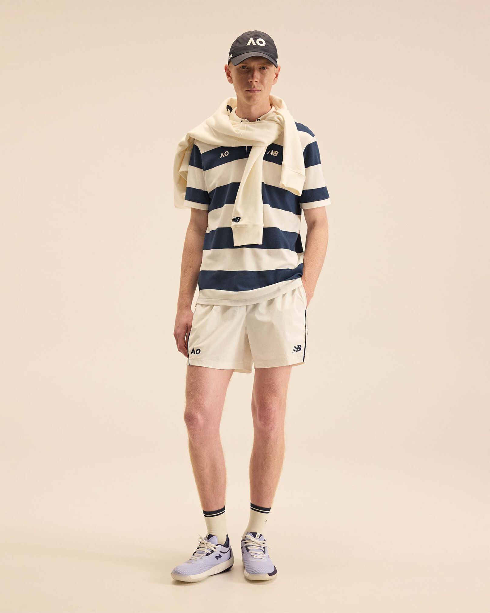 A person standing against a tan studio backdrop.