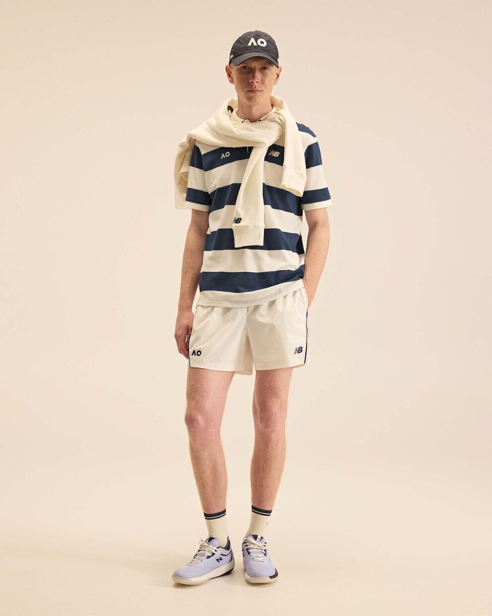 A person standing against a tan studio backdrop.