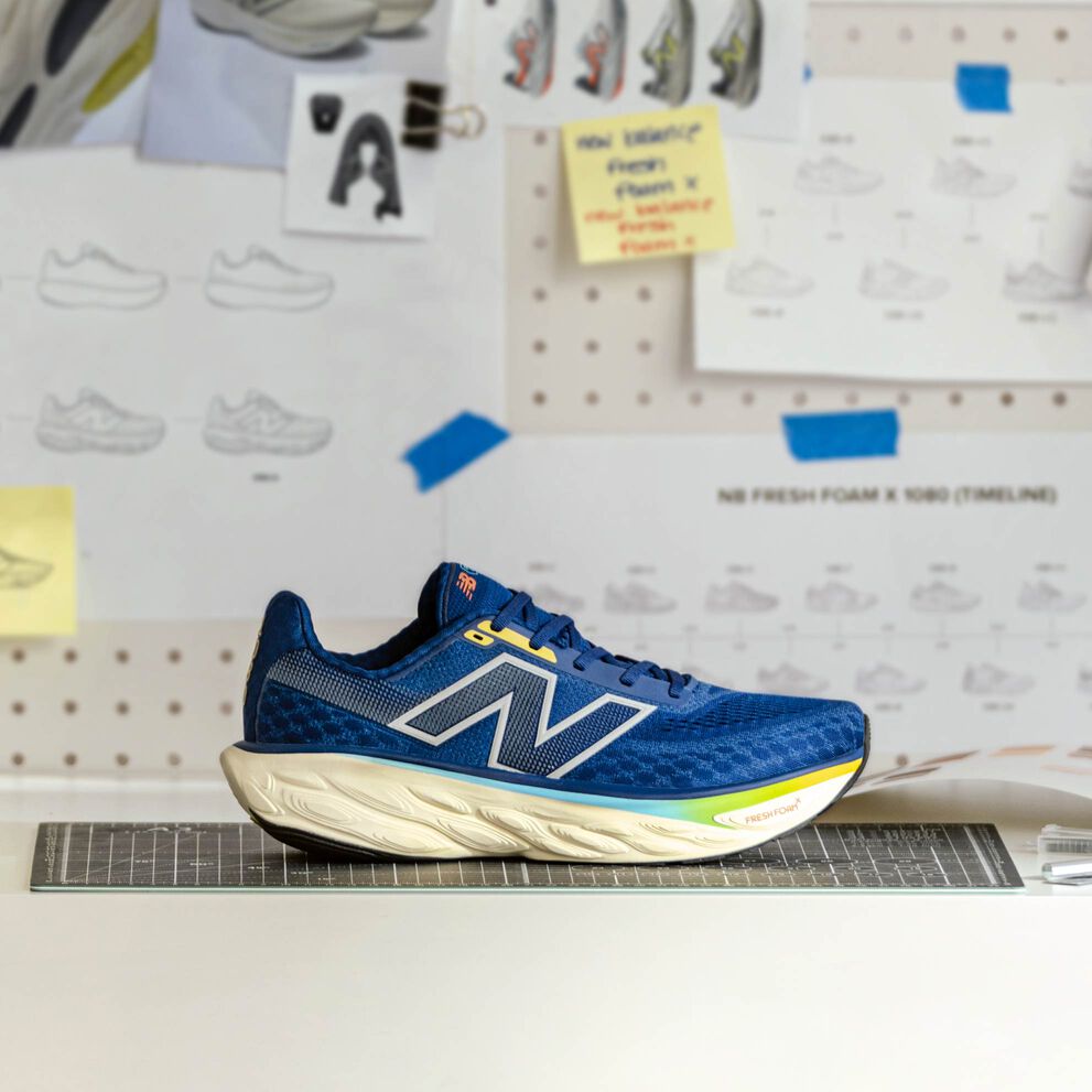 A blue Fresh Foam X 1080 shoe on a table in a workshop.