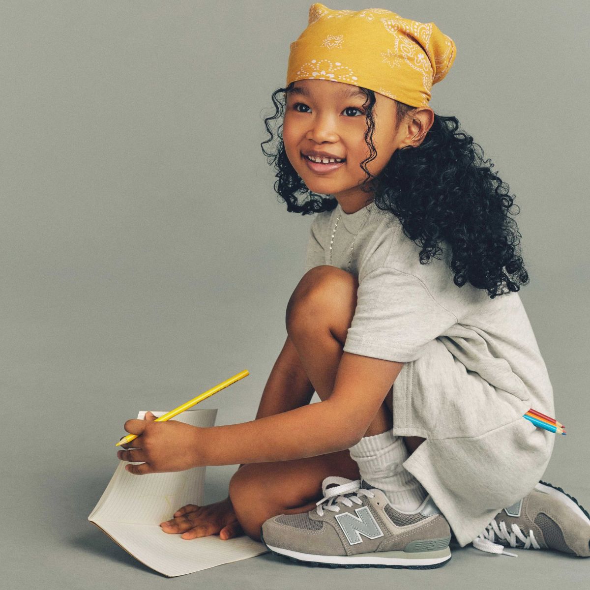 Young girl posing in front of a bike wearing New Balance 9060 sneakers 