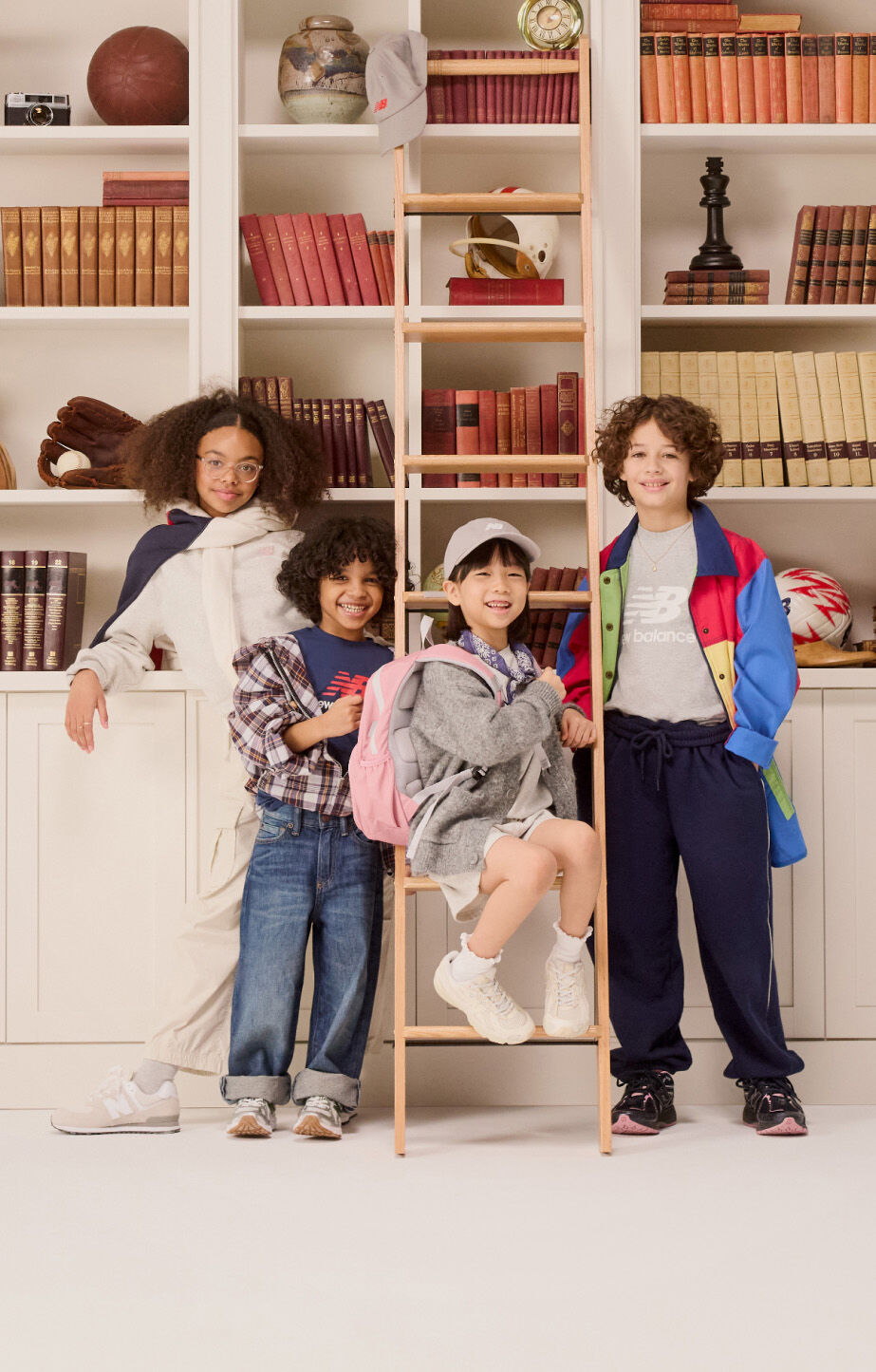 Group of young kids standing in front of a bookshelf. 