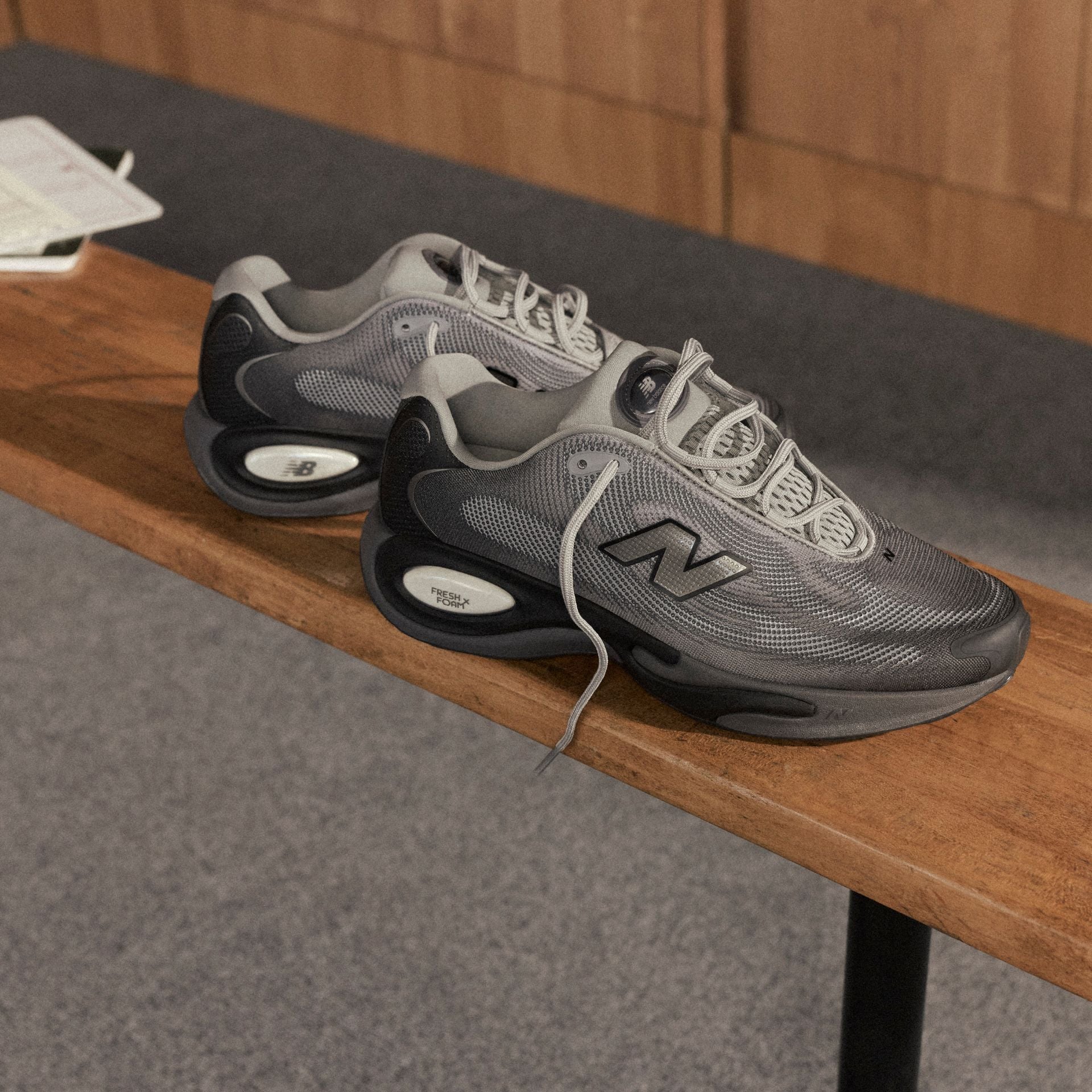 Pair of grey running shoes on a locker room bench