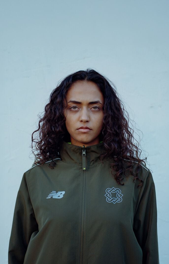 Headshot of a woman standing against a blue wall 