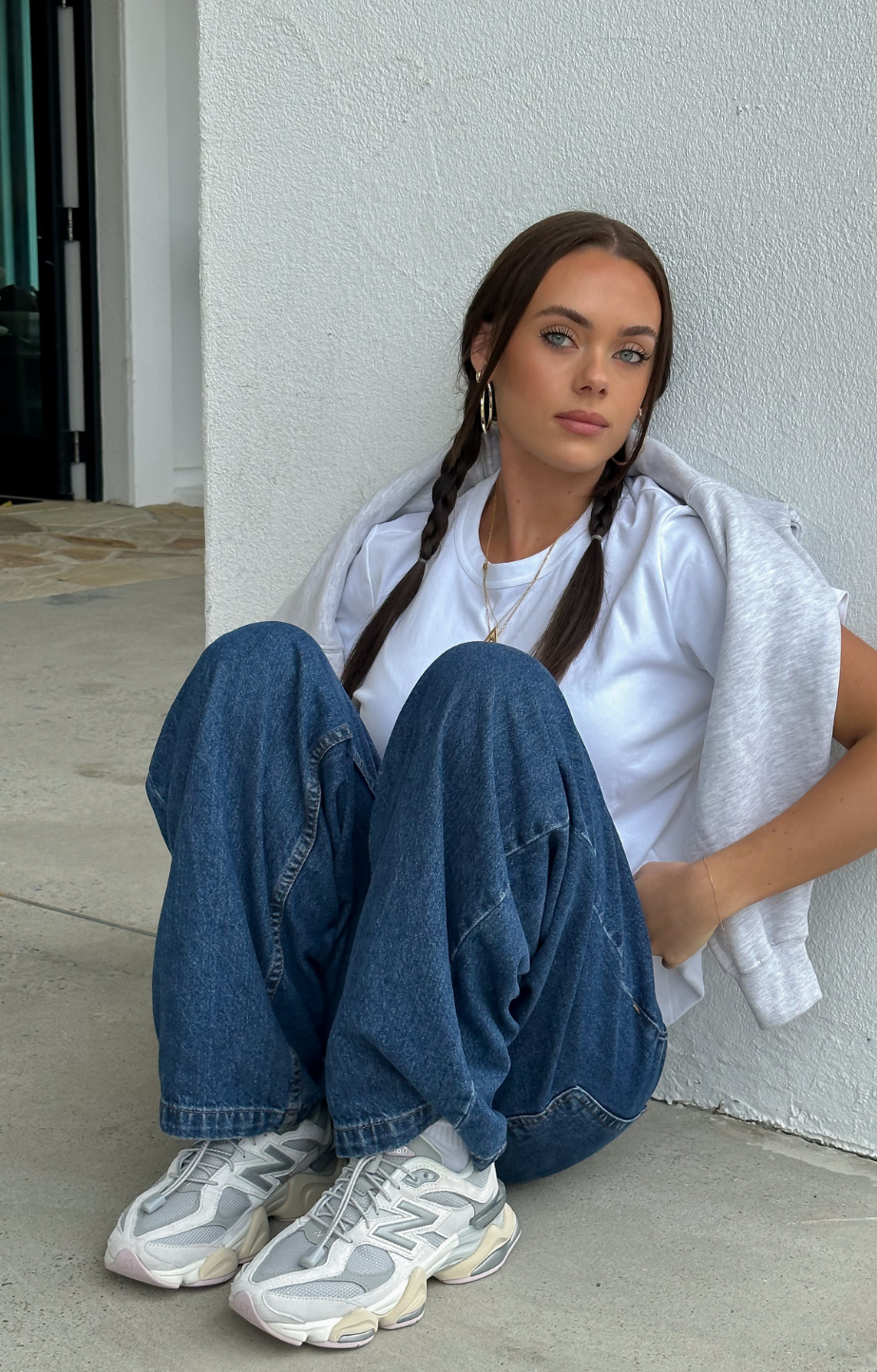 woman sitting on a chair wearing New Balance 9060 shoes