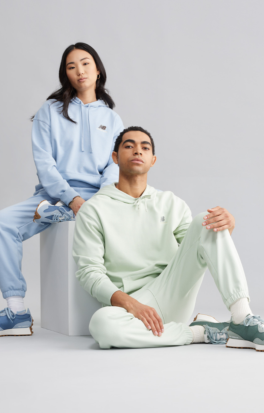 a man and woman wearing New Balance uni-ssential clothing and 327 shoes