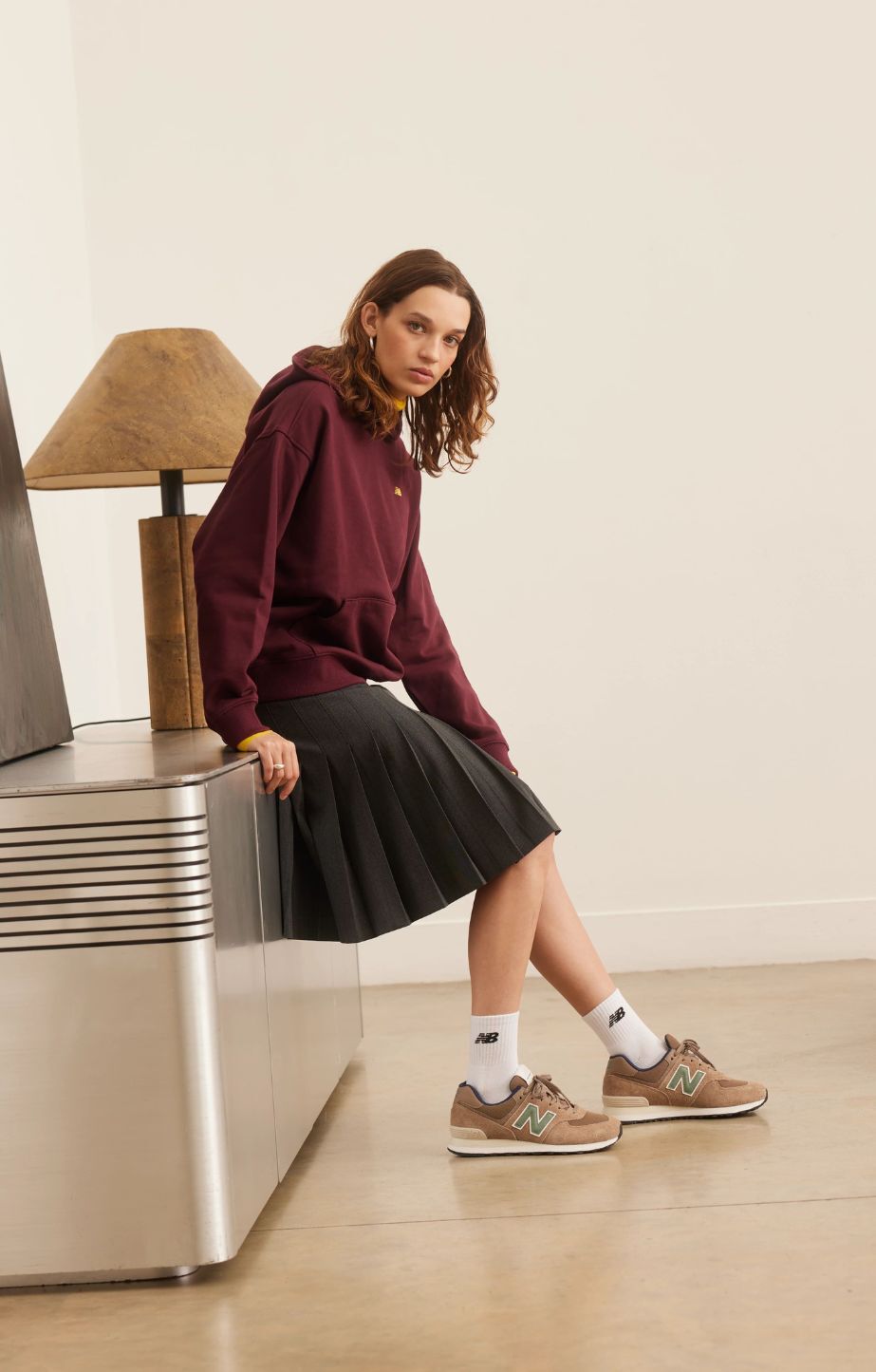 woman leaning on bench wearing New Balance 574 sneakers