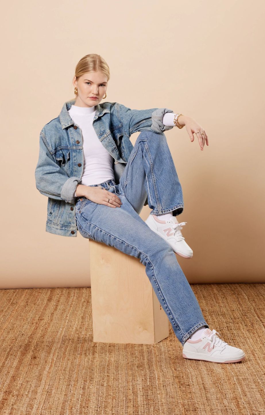 Woman sitting on pillar wearing new balance 480LOP