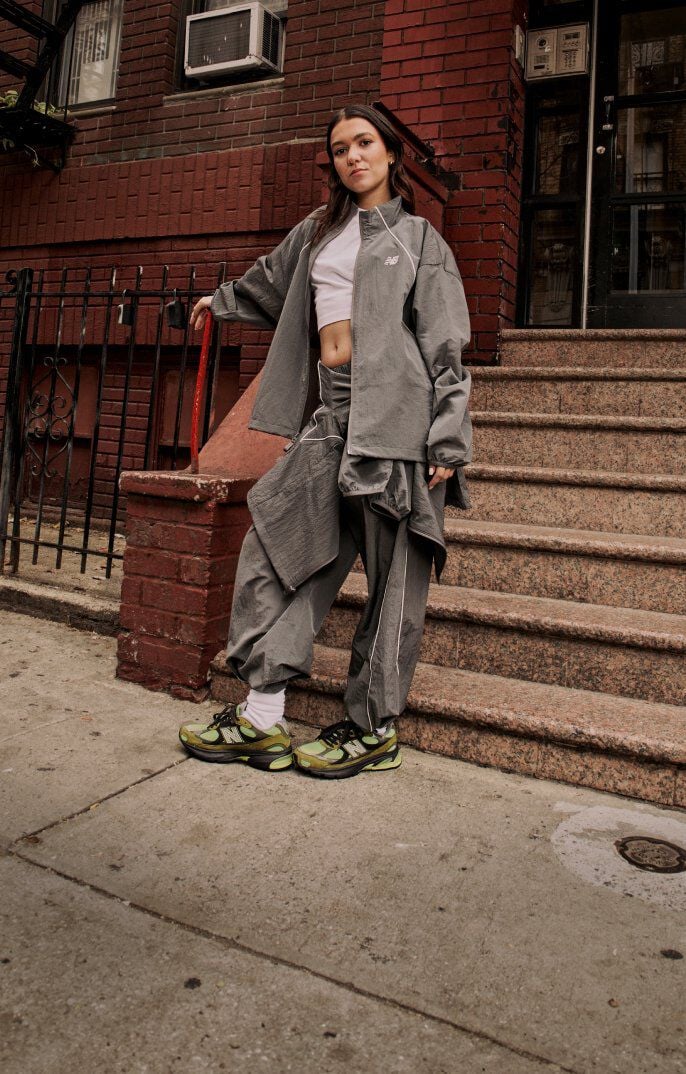 Woman standing next to steps, holding onto the railing. 