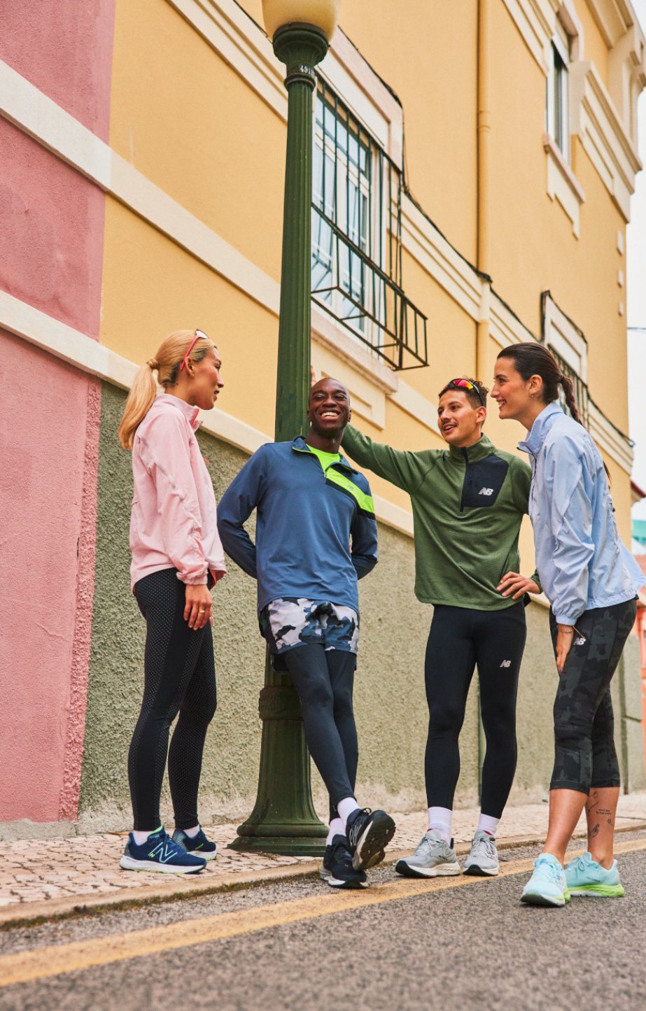 2 women and 2 men standing together wearing New Balance Shoes and Apparel